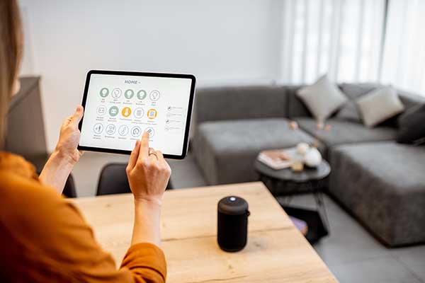 Homeowner checking energy usage on a tablet connected to smart HVAC controls